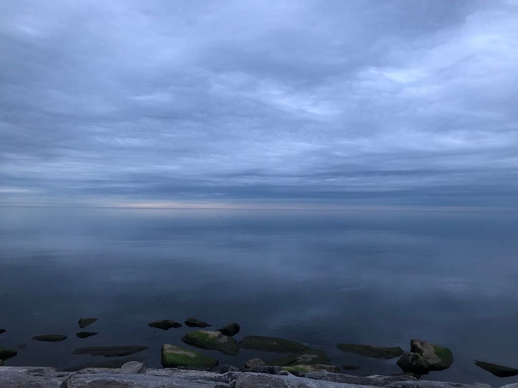 A deep blue image of water and sky in a pre-sunrise sky on Lake Ontario at Oakville.