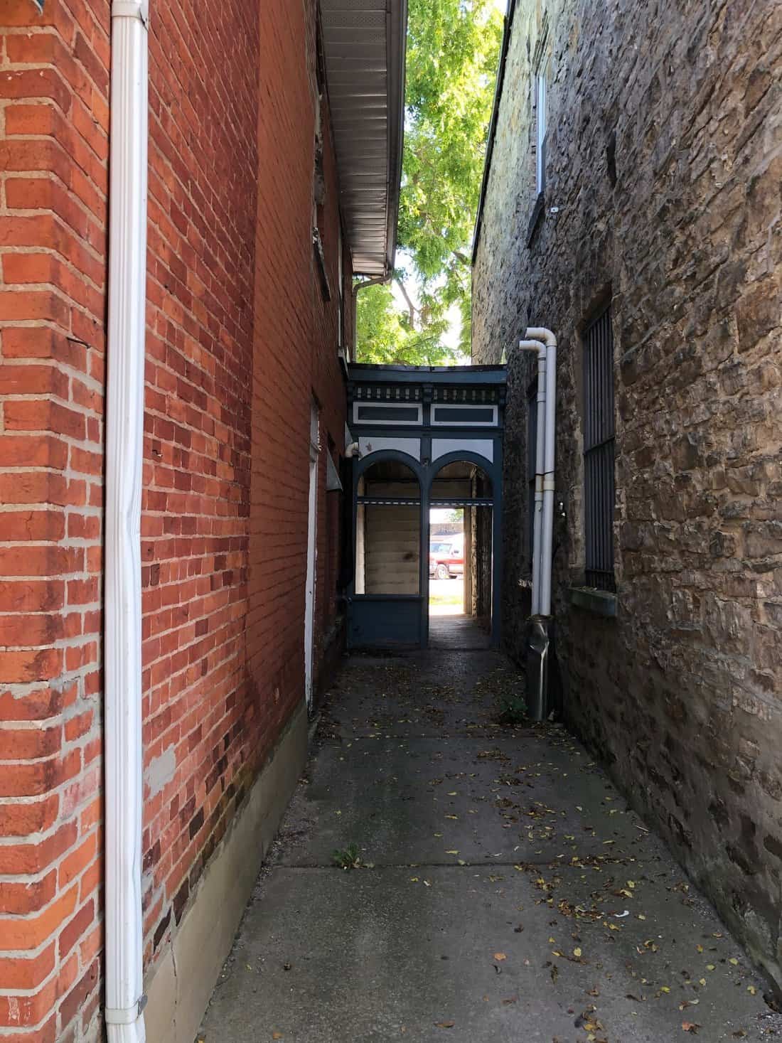 Common rational purpose—alleyway, with shared by-lateral breezeway, downtown Gananoque, September 2023.