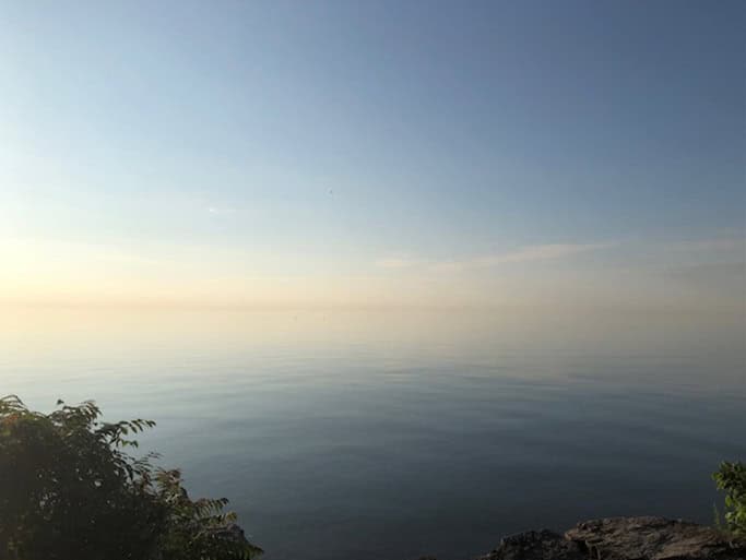 Author’s photograph, Lake Ontario looking East, after a hazy sunrise, Oakville, July 2024.