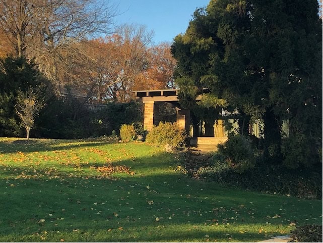 Long shadows across a lush green lawn dappled with fall leaves. Focus on former Tea House at SE corner of Gairloch Gardens, Nov 2024.